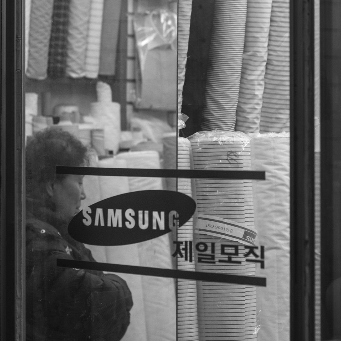 Femme coréenne derrière une vitrine samsung, photographie, hiver