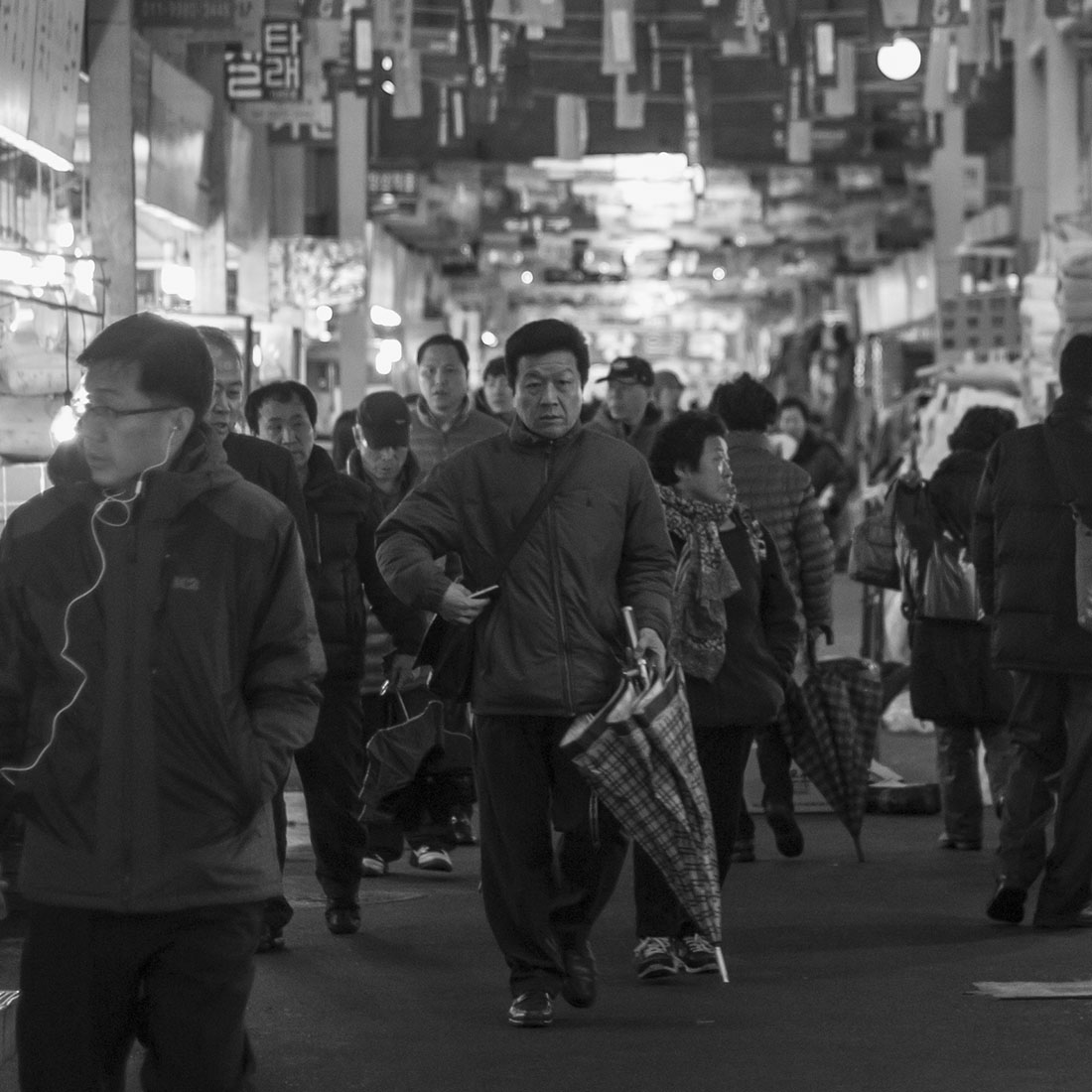 Homme marchant avec son parapluie, Séoul, photographie de rue, marché de nuit, noir et blanc