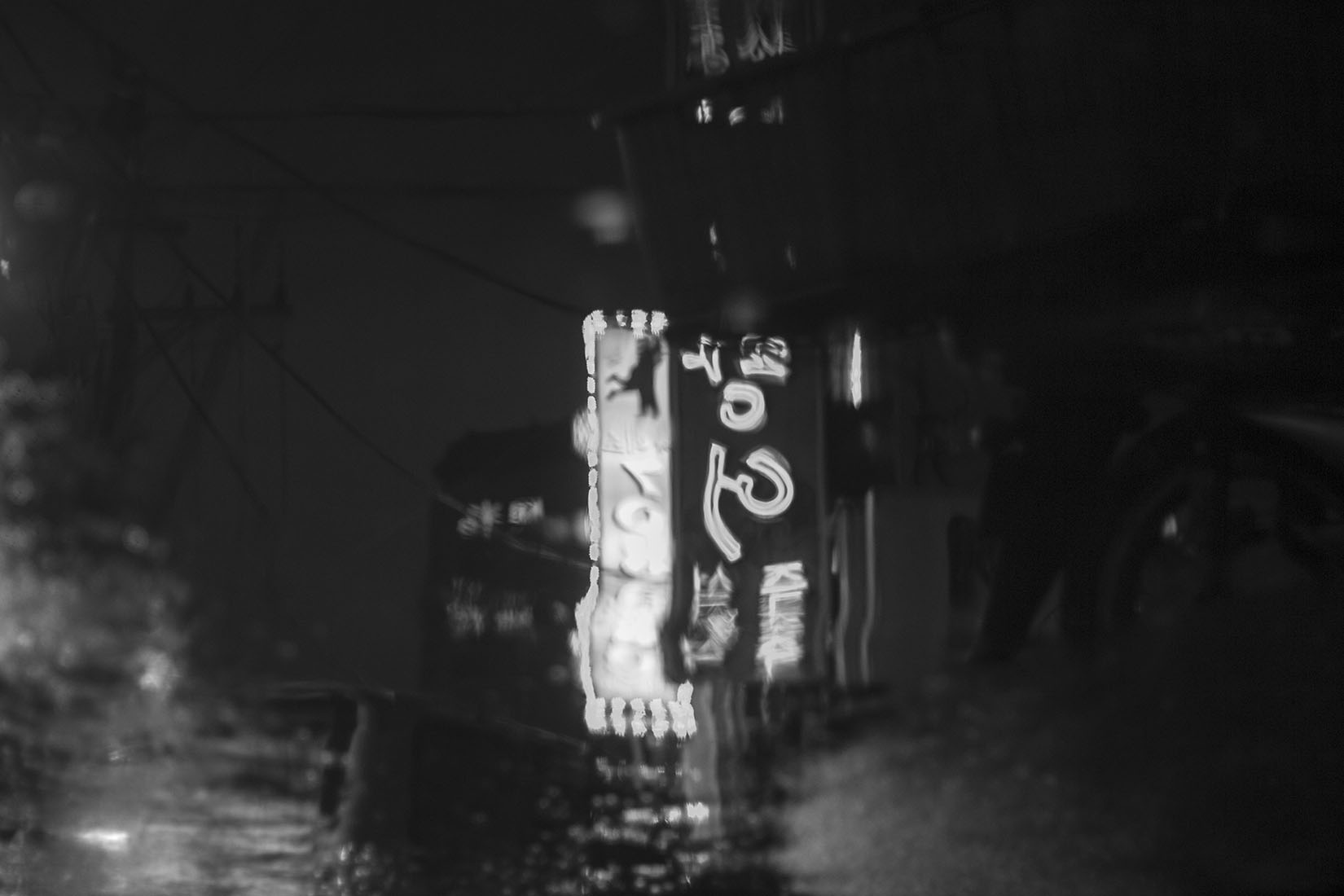 Reflets typographiques déformés, eau, pluie, nuit coréenne, Séoul